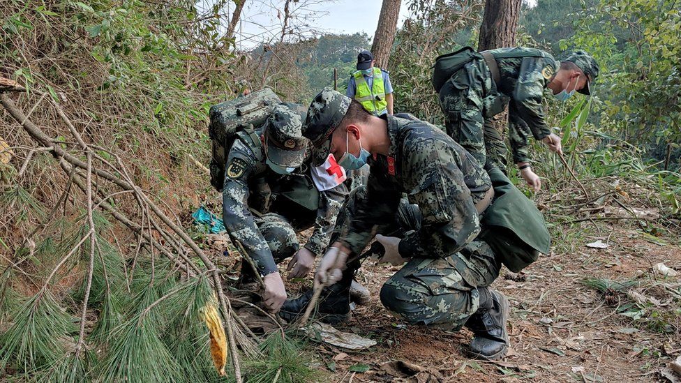 China plane crash: Rescuers search for survivors as families await news
